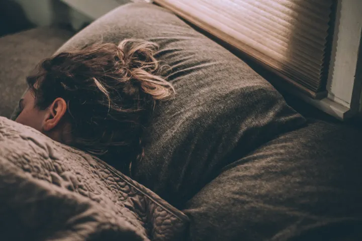 Femme endormie sous une couette dans la lumière du matin